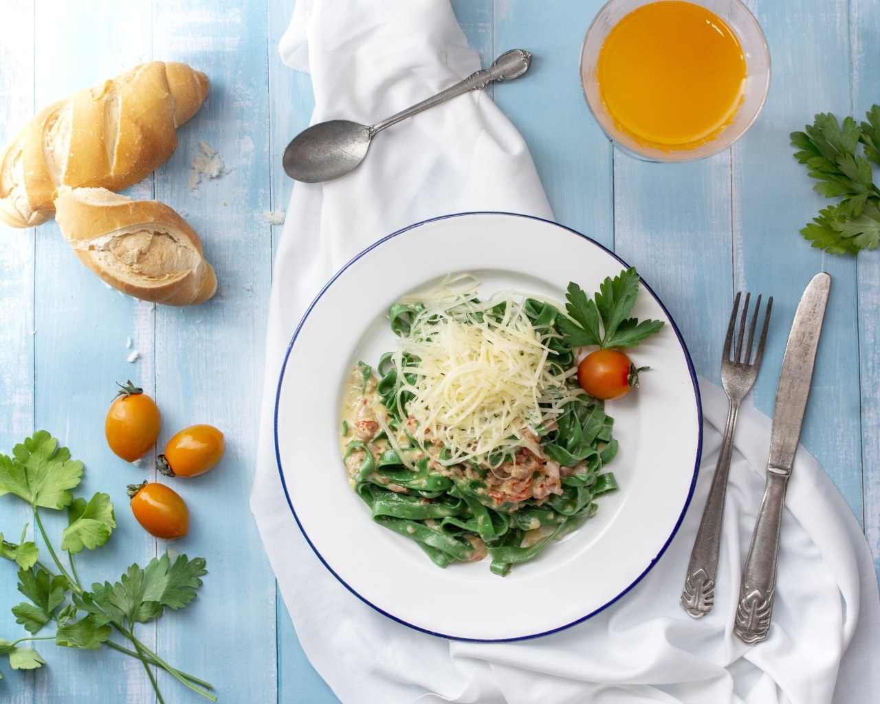 Зеленая лапша с сыром на столе с хлебом и зеленью