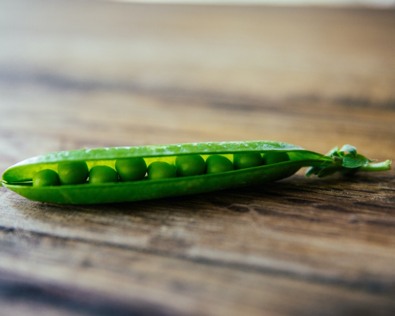 Зеленый горох на деревянном столе