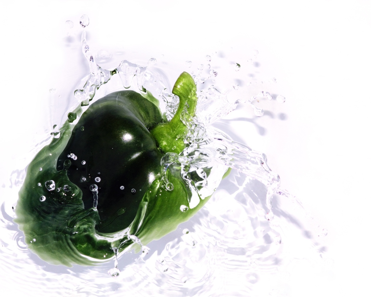 Зеленый перец в воде на белом фоне