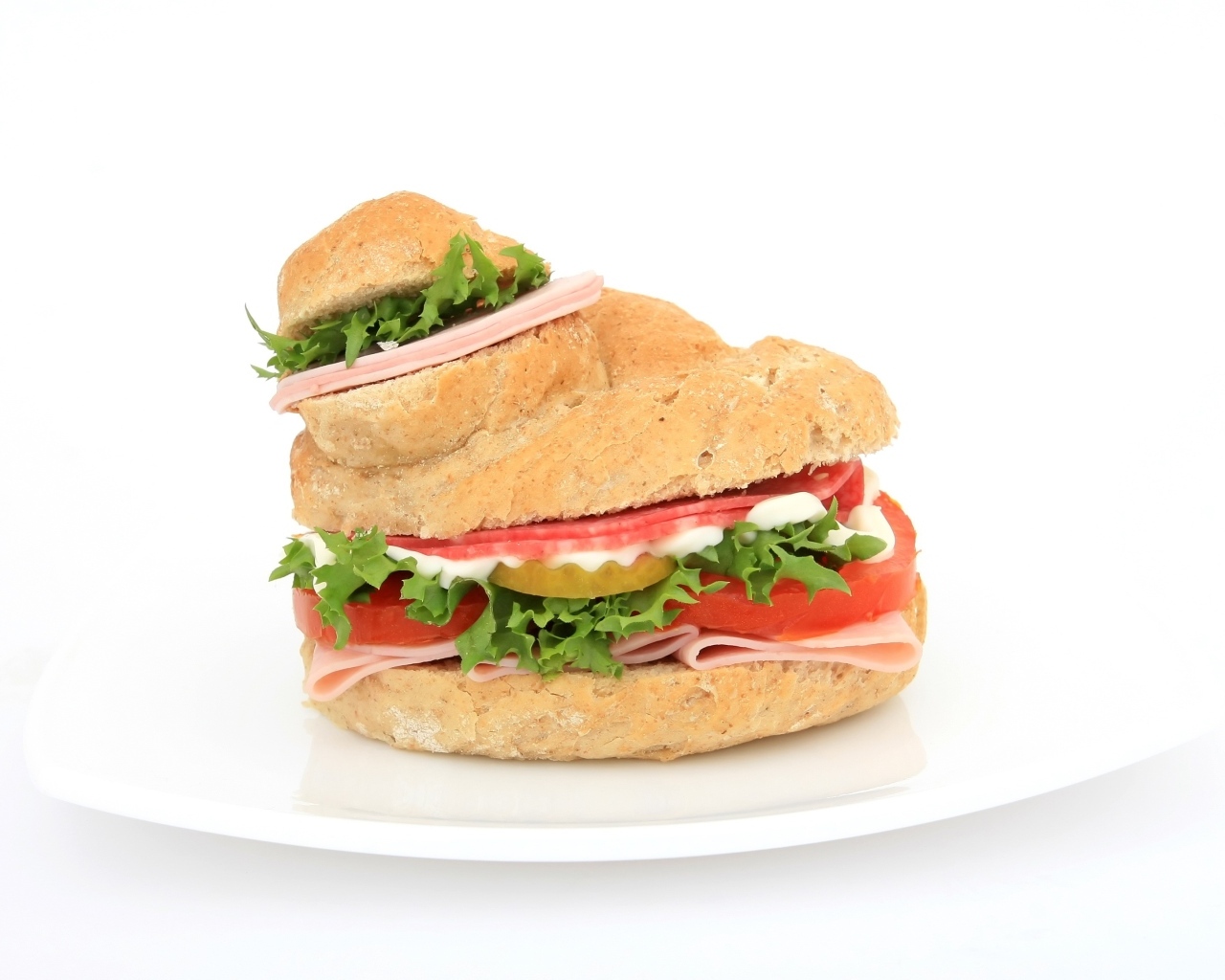 Гамбургер с колбасой, томатами и листьями салата на белом фоне