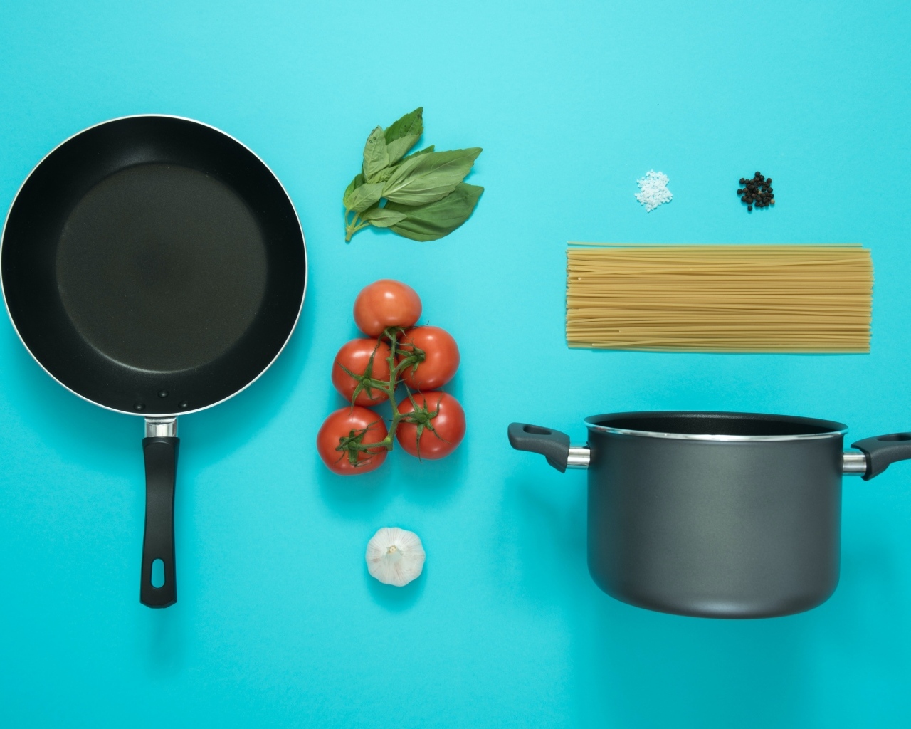Ингредиенты и посуда для спагетти на голубом фоне