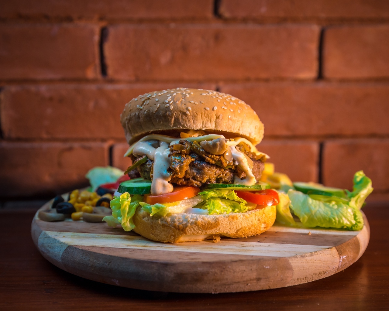 Большой аппетитный гамбургер на фоне стены