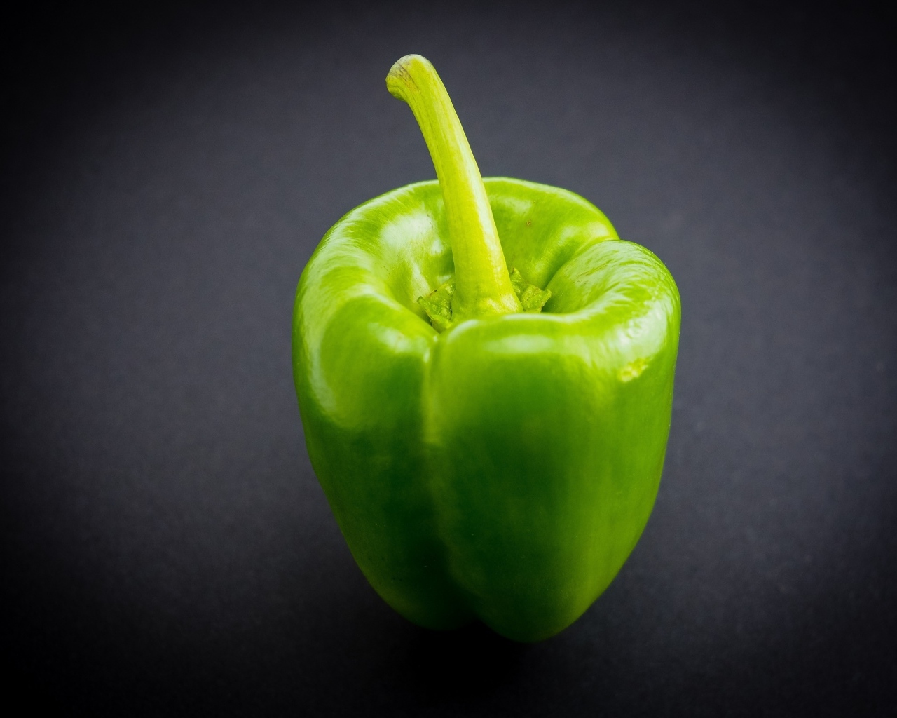 Большой зеленый перец на сером  фоне