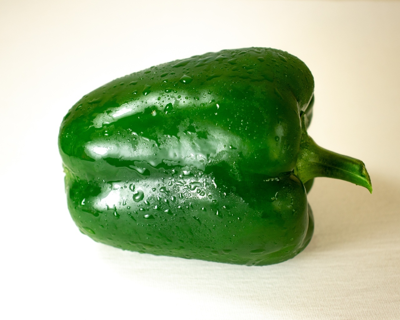 Крупный зеленый перец на белом фоне