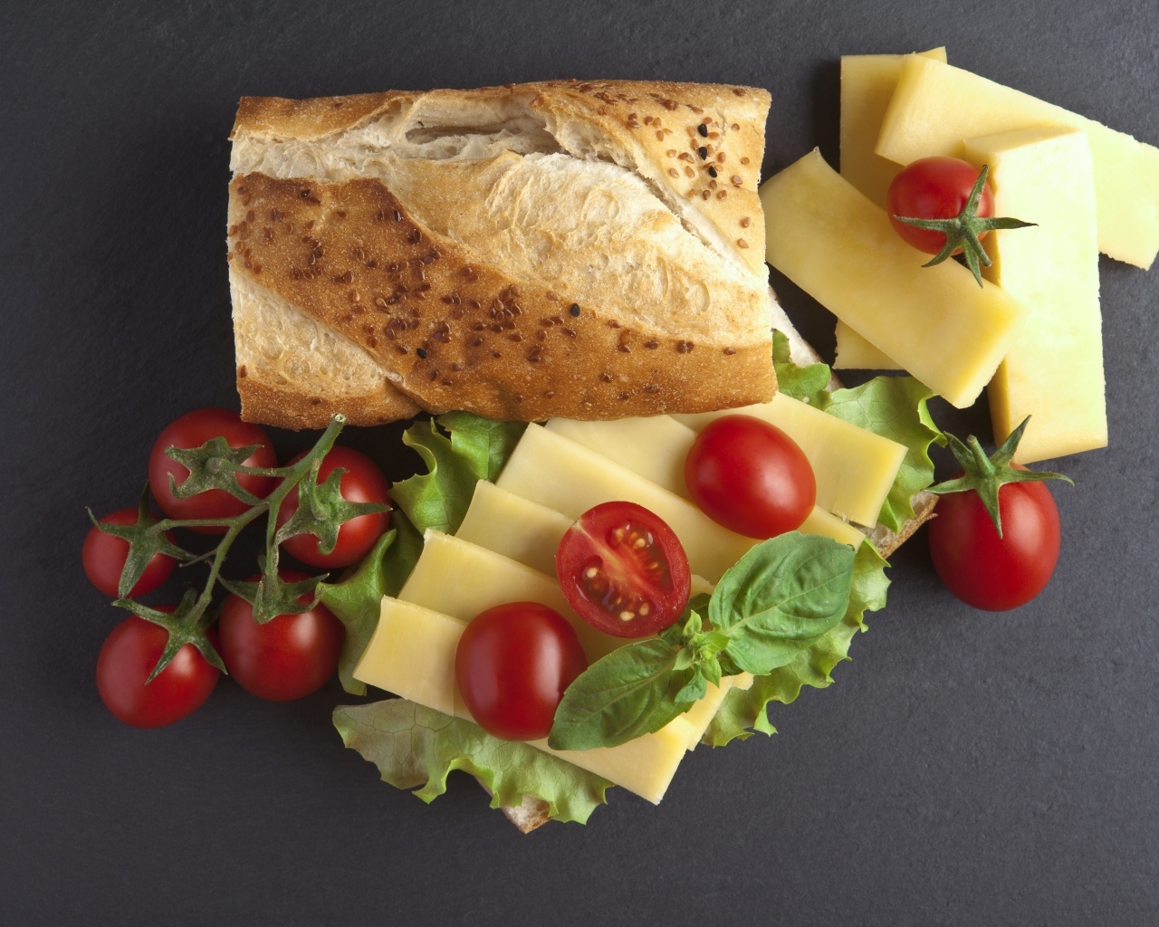 Батон с сыром и помидорами на сером фоне