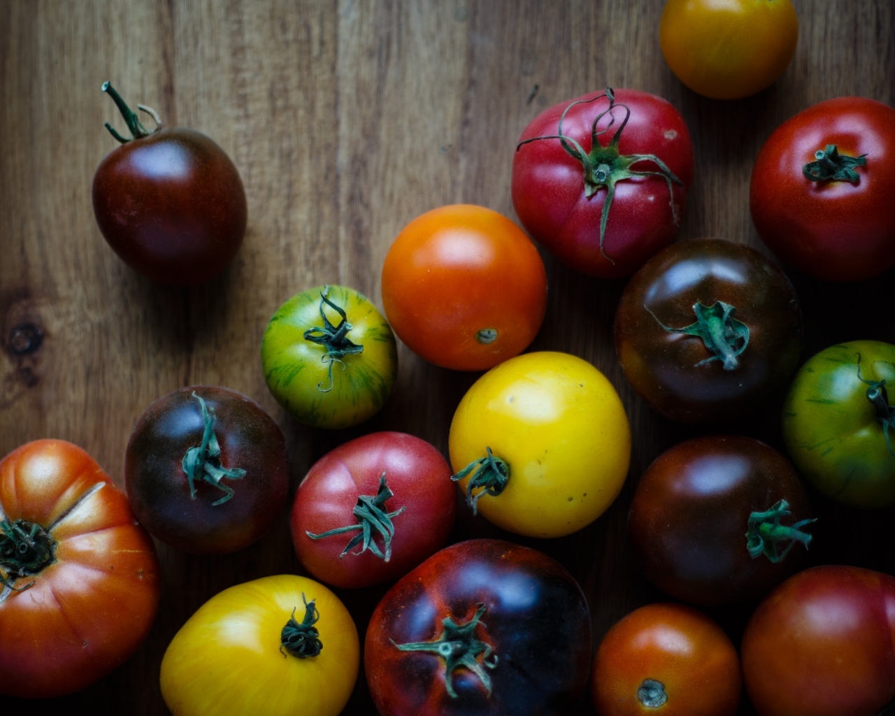 Разноцветные помидоры на деревянном столе