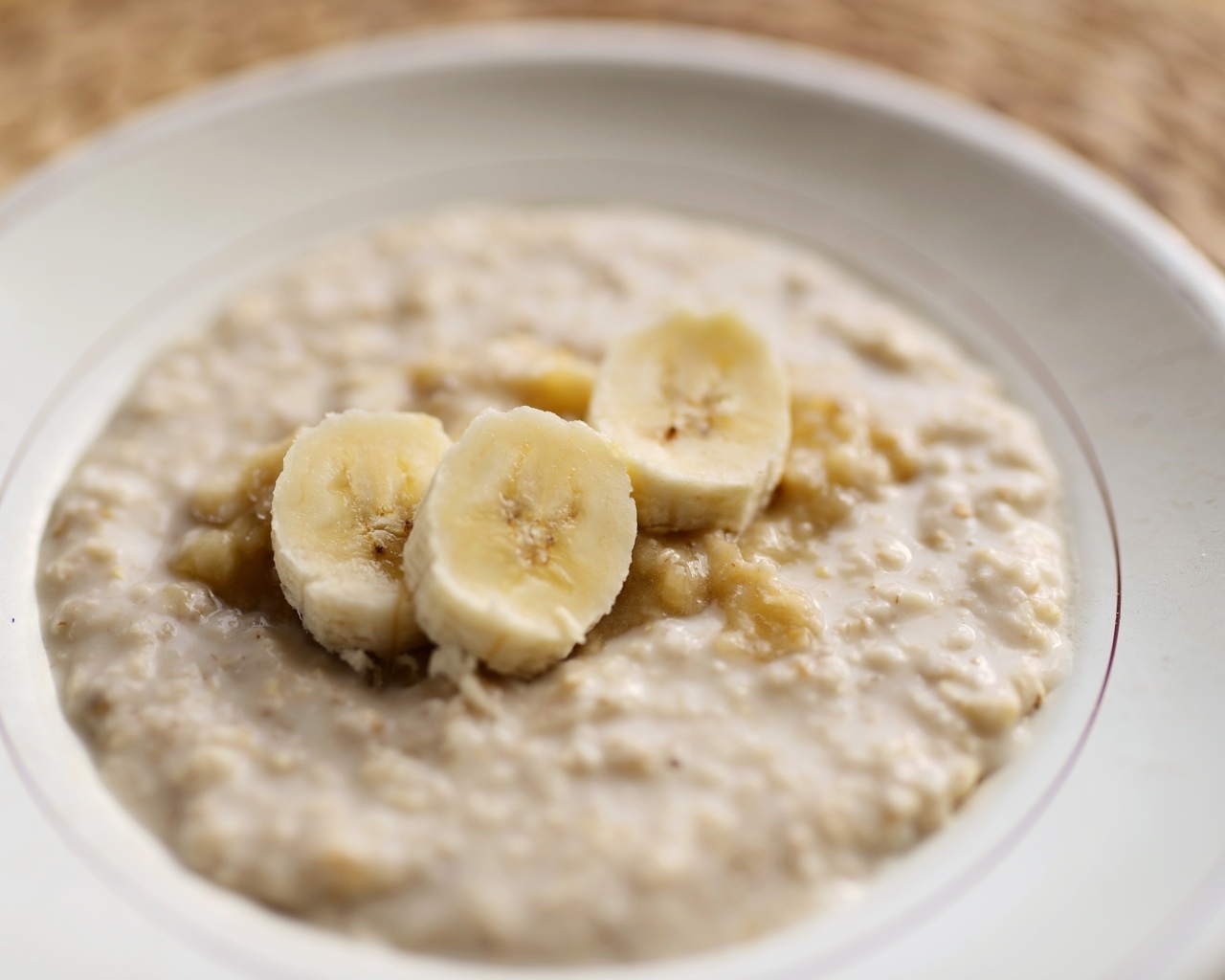 Овсяная каша с кусочками банана в тарелке