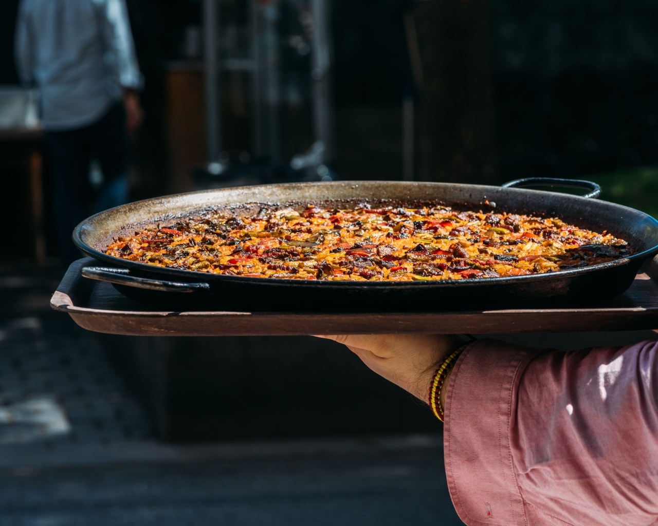 Блюдо паэлья в руках 