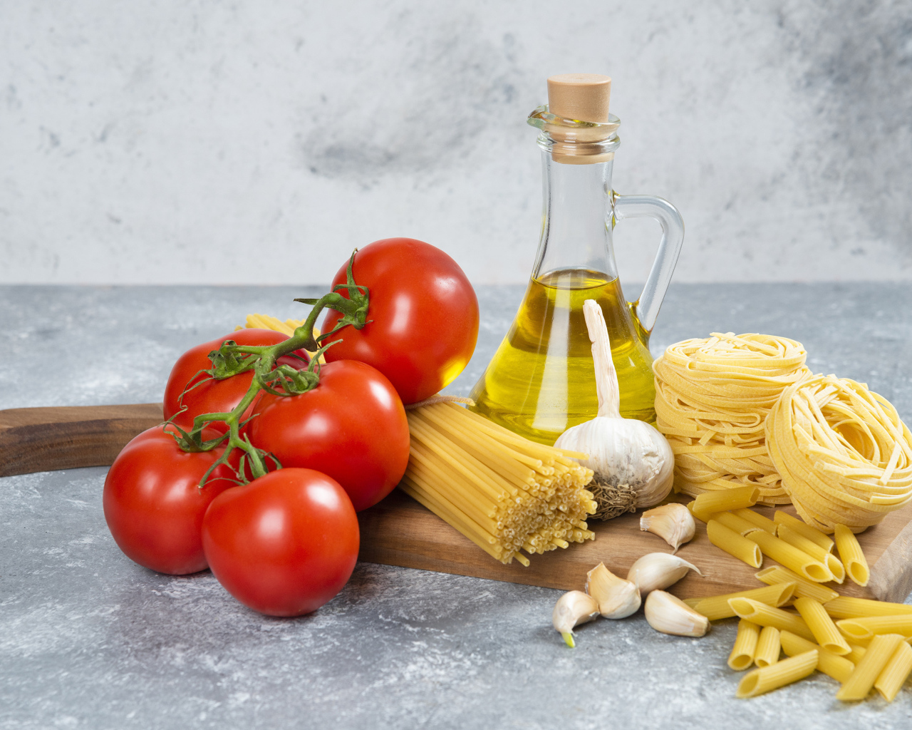 Паста, помидоры и масло на столе