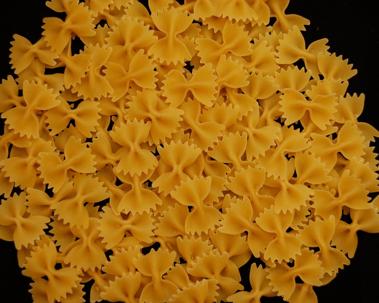 Макароны в форме бантиков на черном фоне