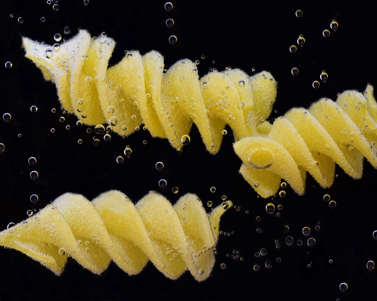 Макароны в воде на черном фоне