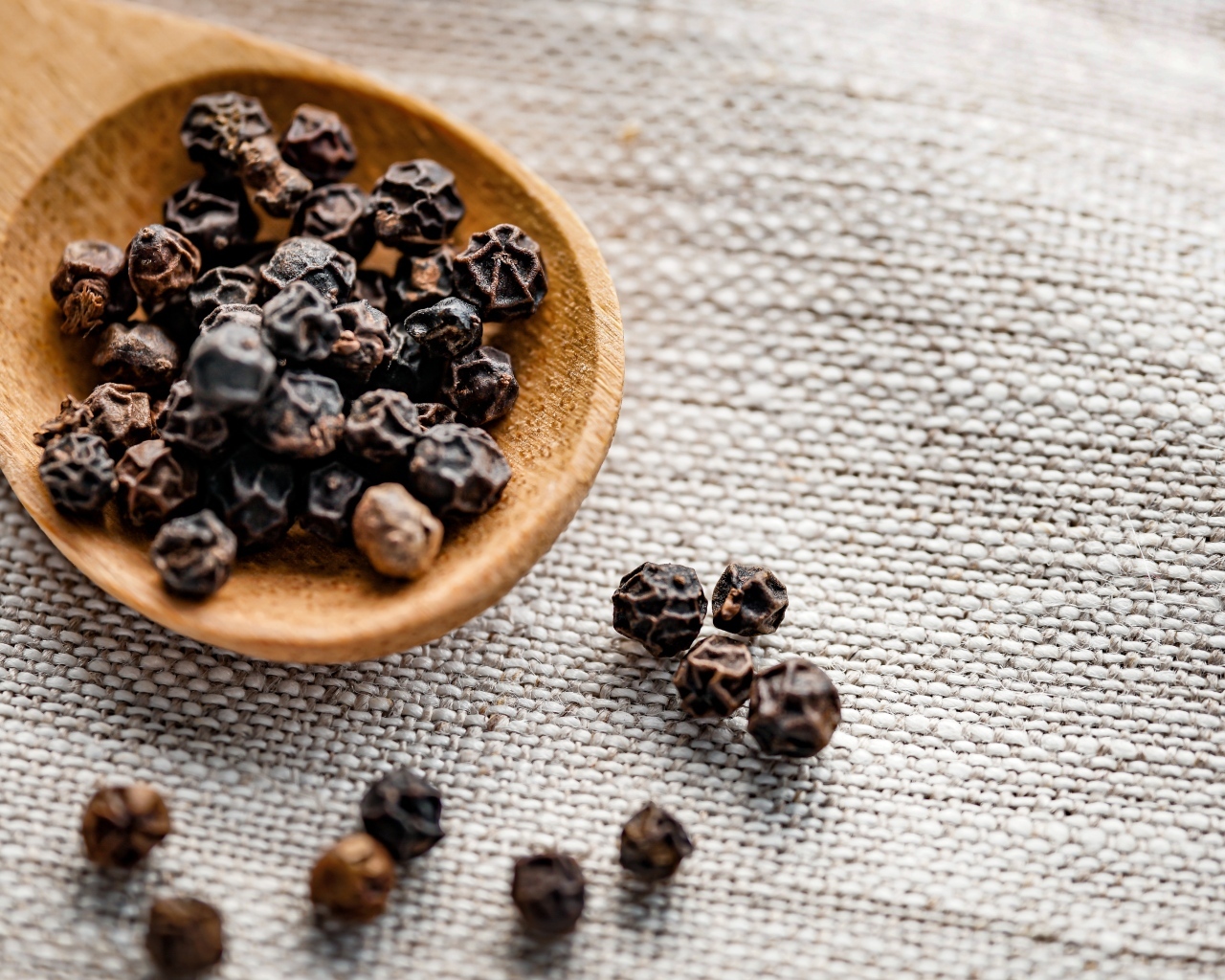 Перец горошком на деревянной ложке