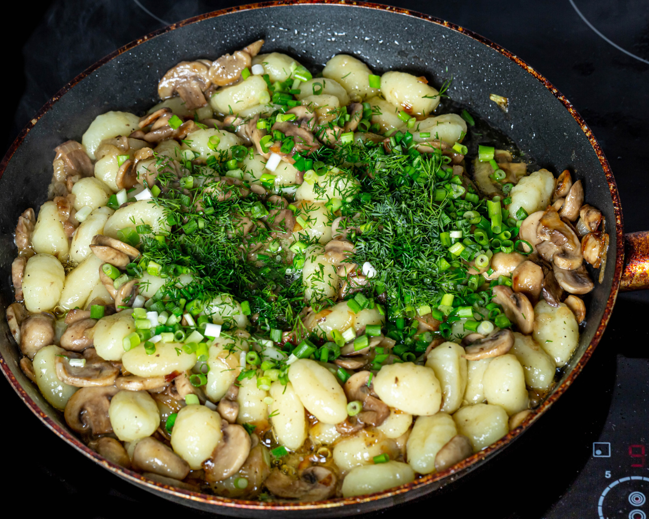 Картофель с шампиньонами и зеленым луков в сковороде