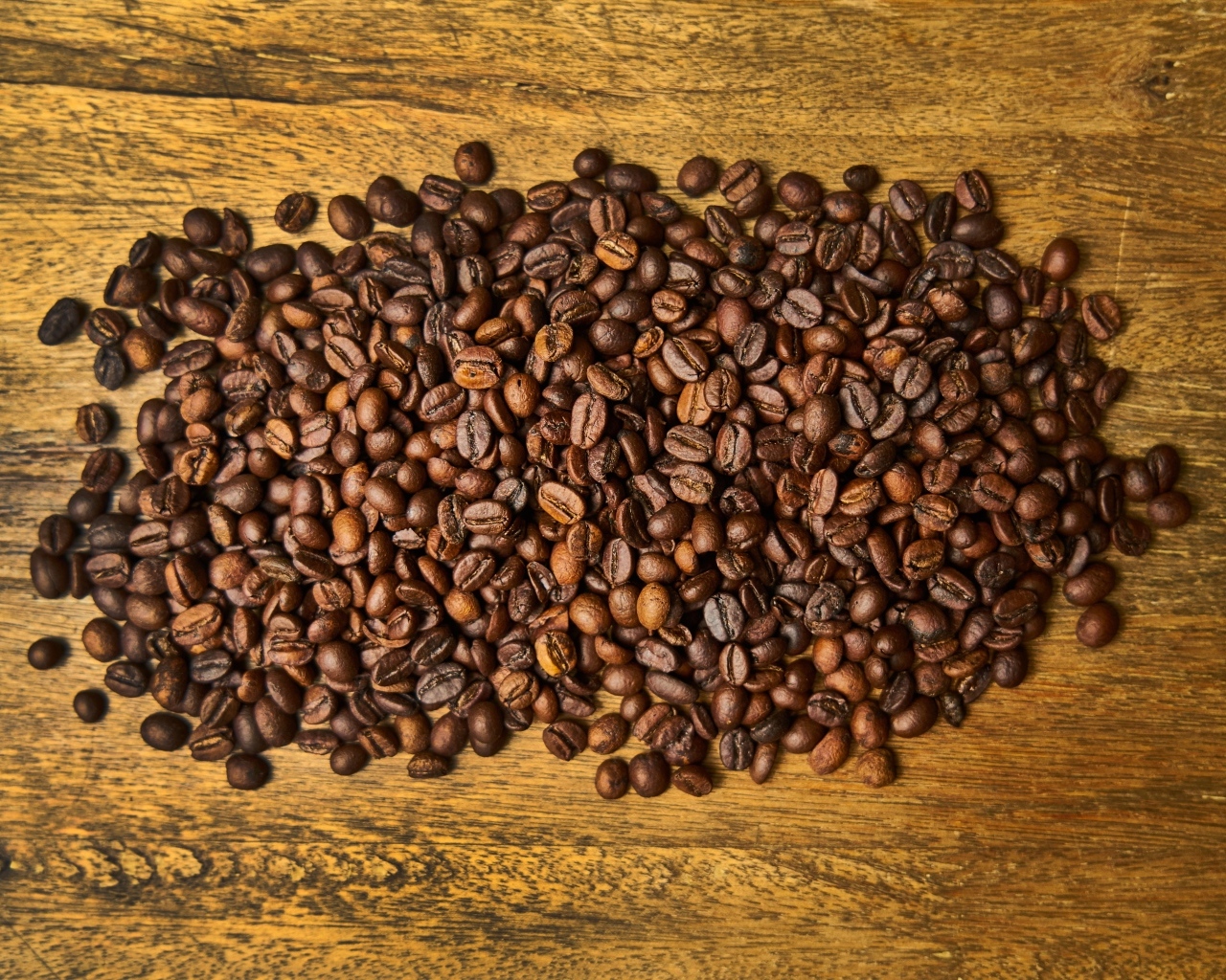 Жареные кофейные зерна на деревянном столе