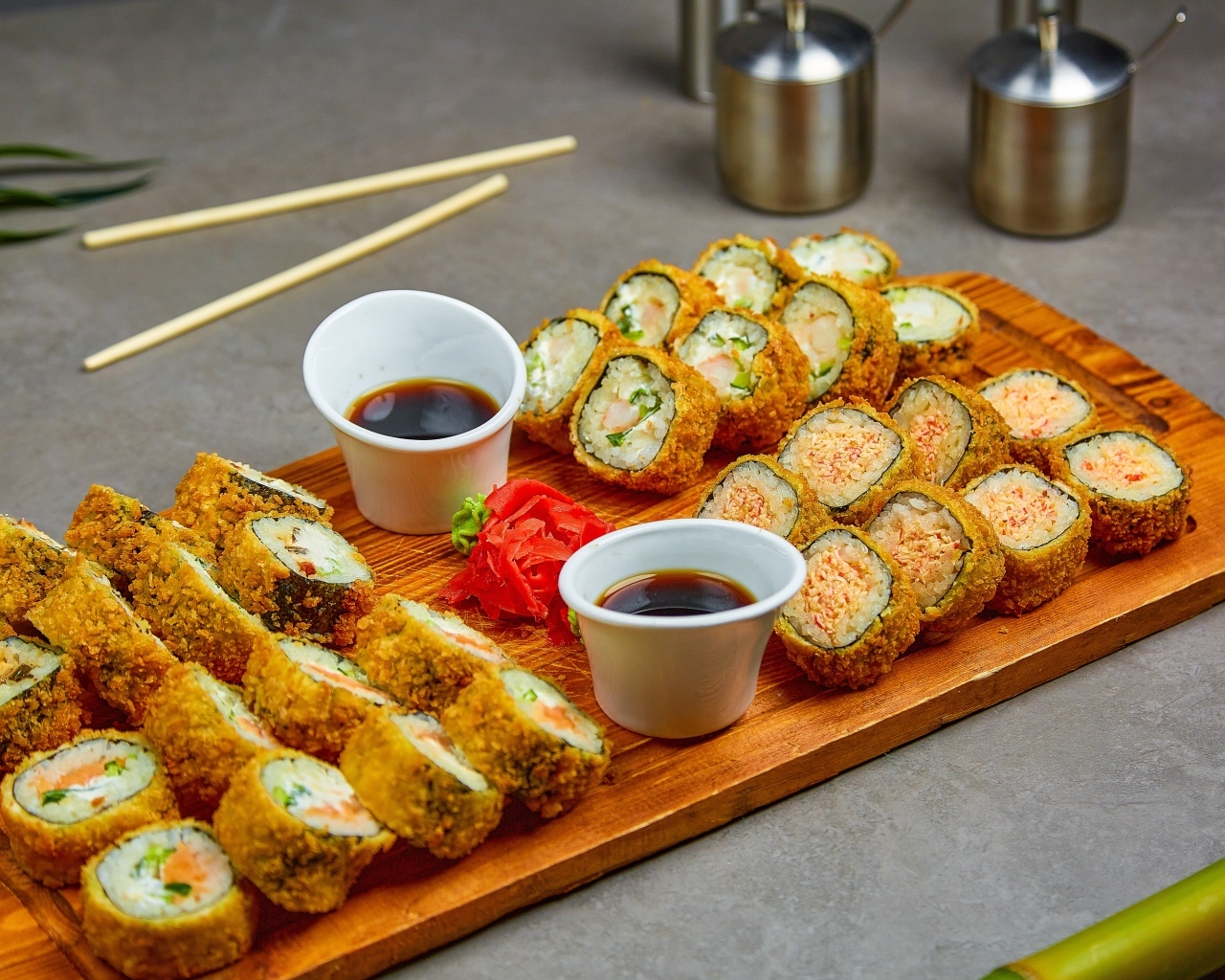 Роллы с соевым соусом на доске на столе