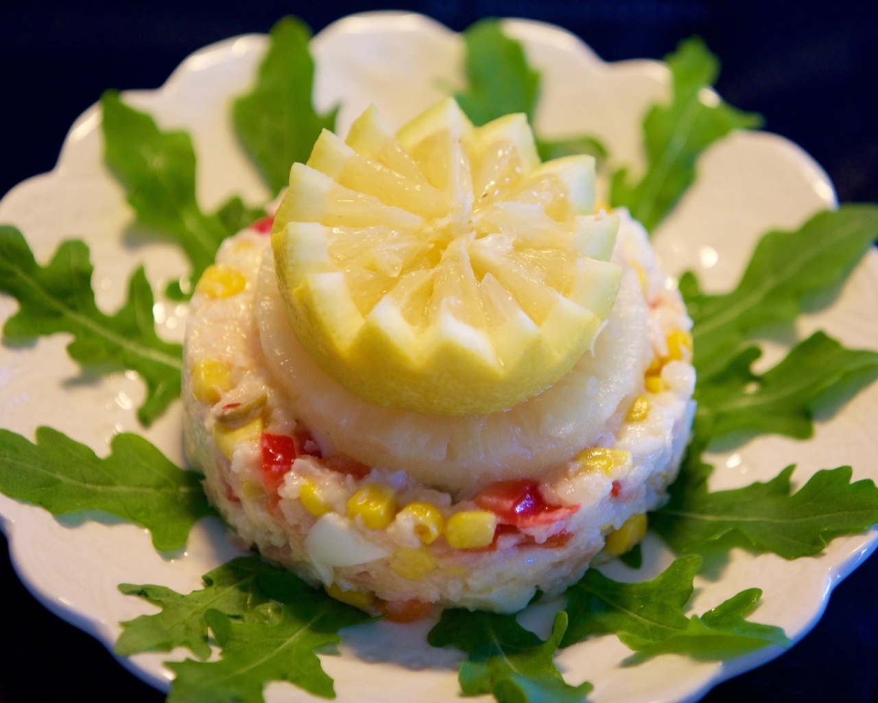 Салат на тарелке с лимоном и рукколой