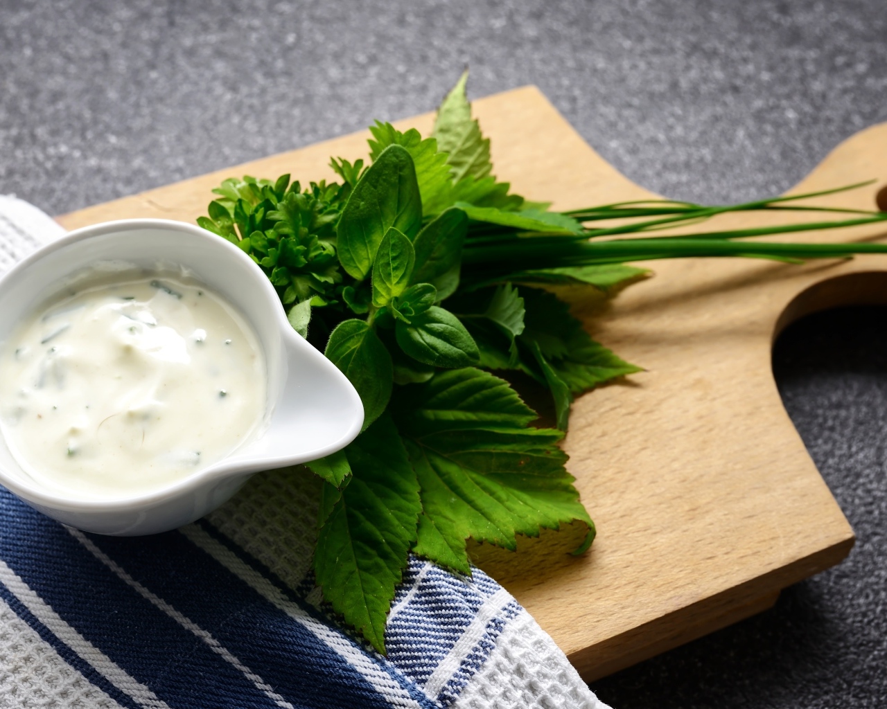 Соус с зеленью на деревянной доске 