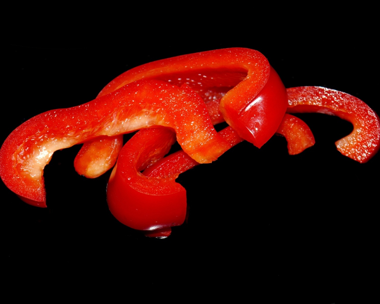 Нарезанный сладкий красный перец на черном фоне