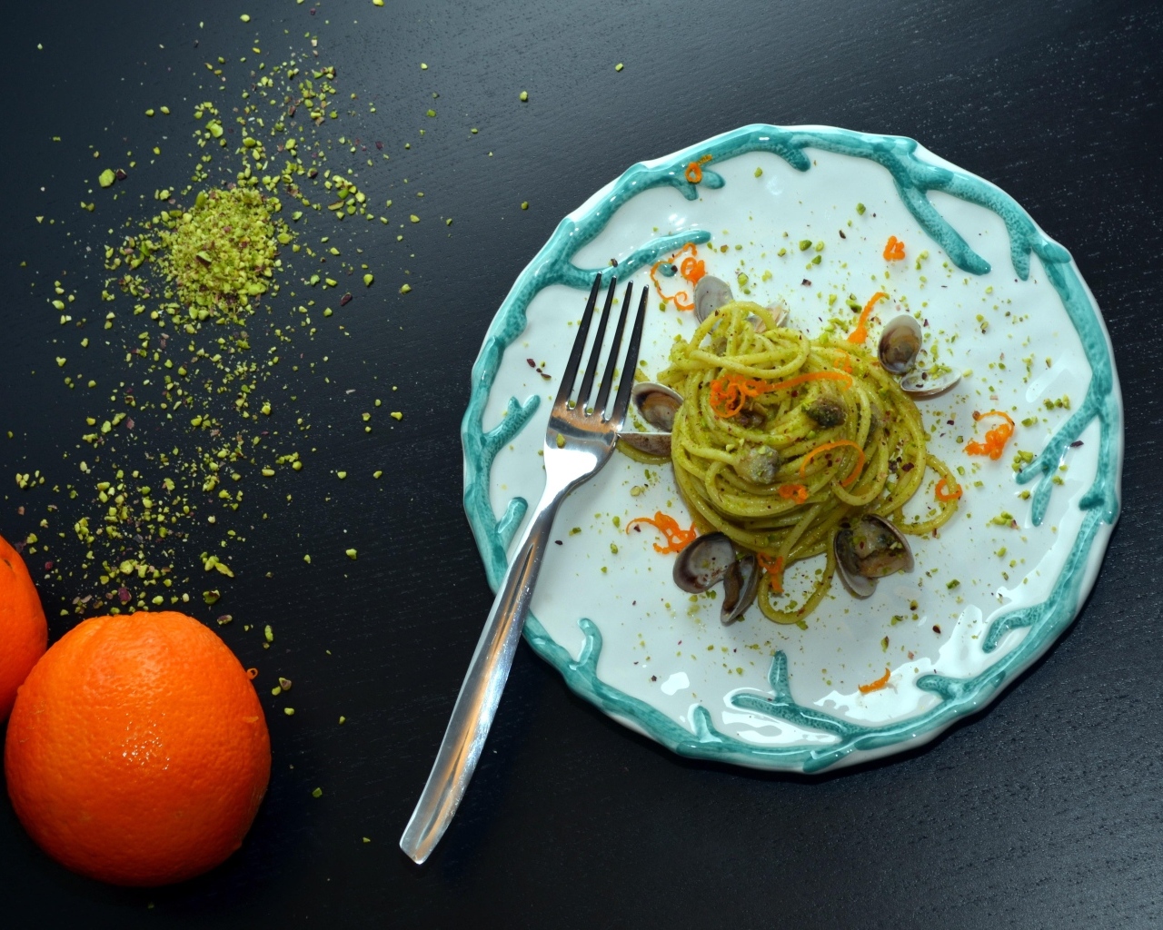 Спагетти с морепродуктами на столе с апельсинами