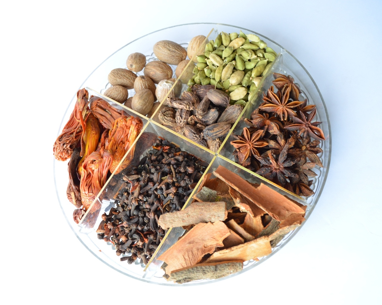 Пряные специи на стеклянной тарелке на столе