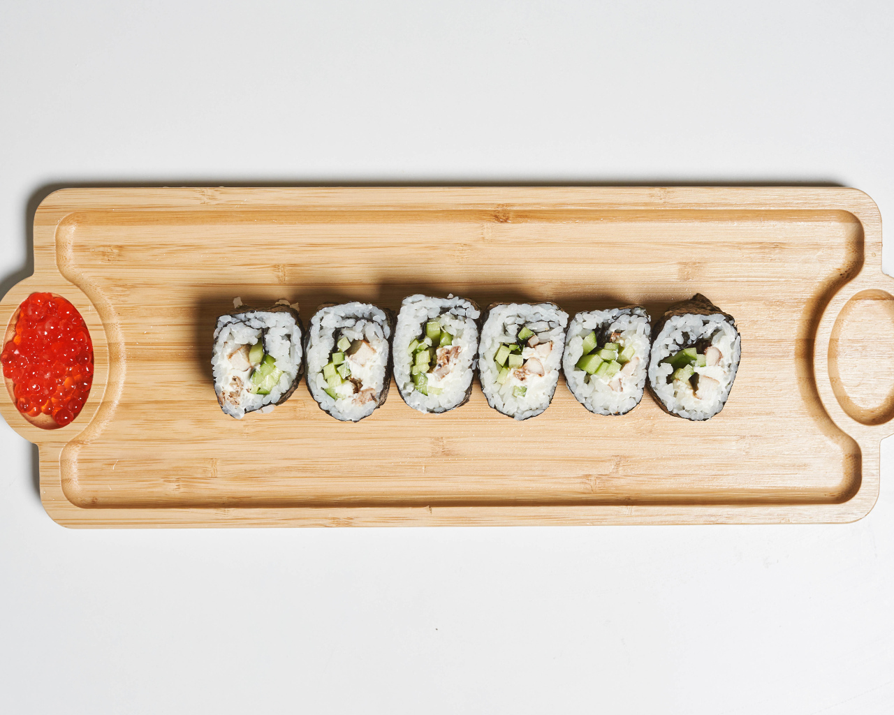 Суши на деревянной доске с  красной икрой