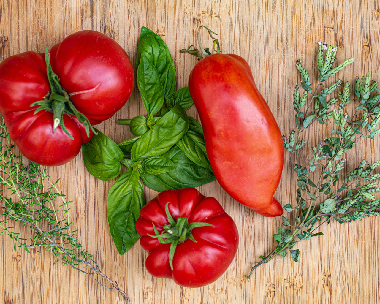 Помидоры  на разделочной доске с базиликом