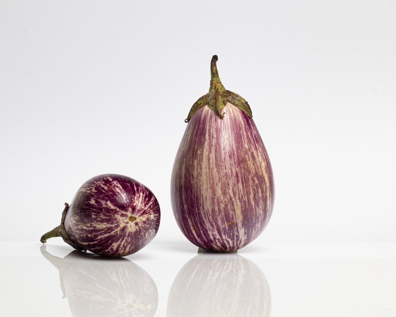 Два баклажана на сером фоне