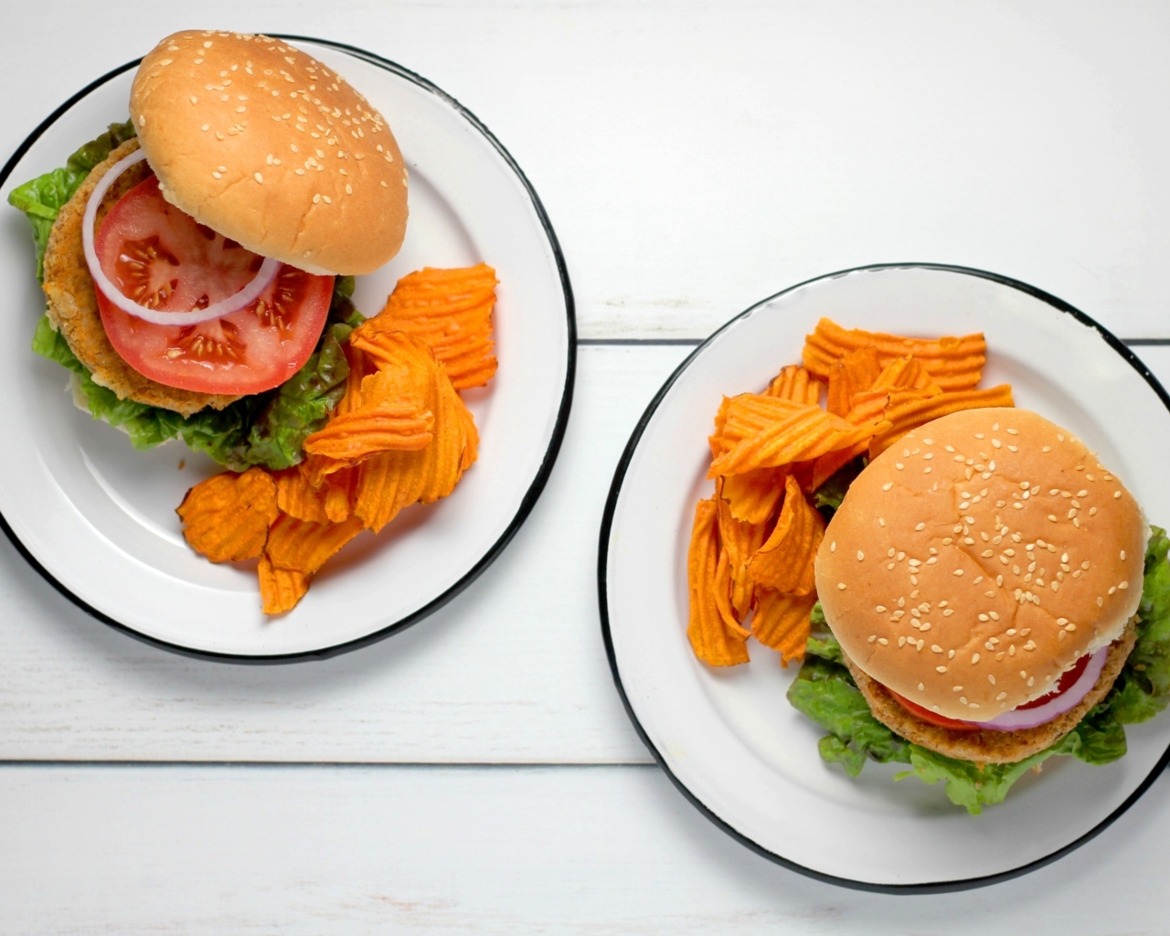 Два гамбургера на тарелке с чипсами
