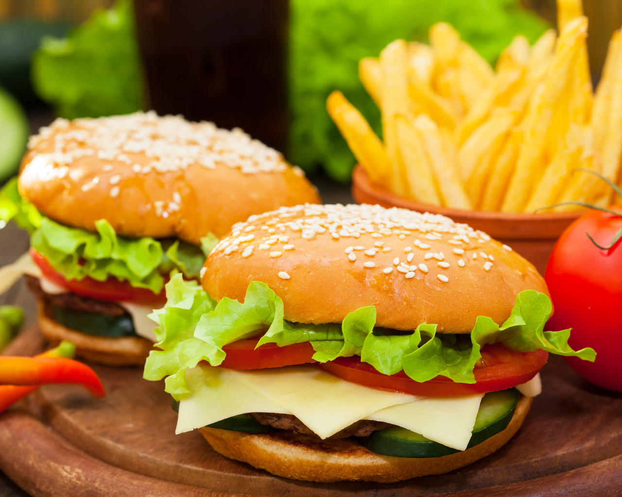 Два больших гамбургера на столе с картофелем фри