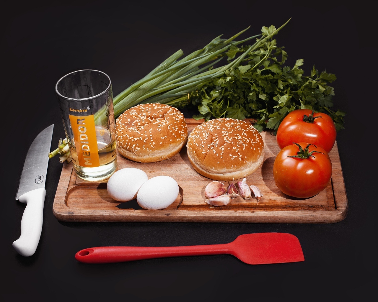 Овощи, яйца, зелень и булочки на черном фоне