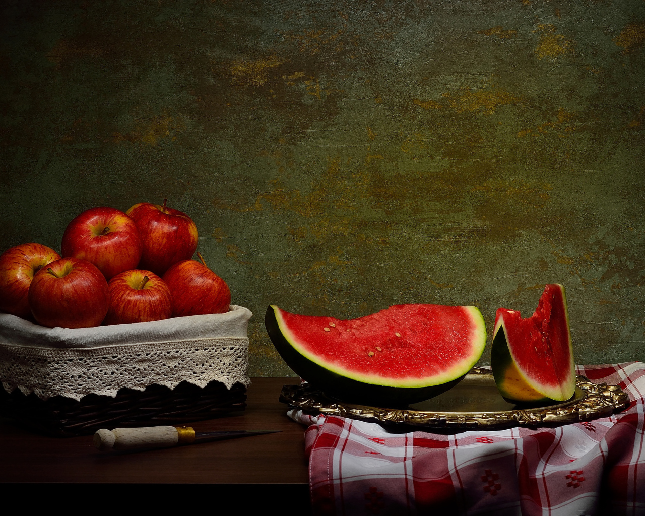 Скибки арбуза на столе с яблоками 
