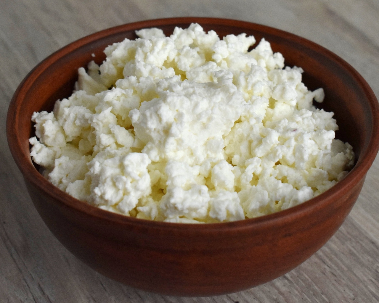 Деревянная миска с творогом на столе