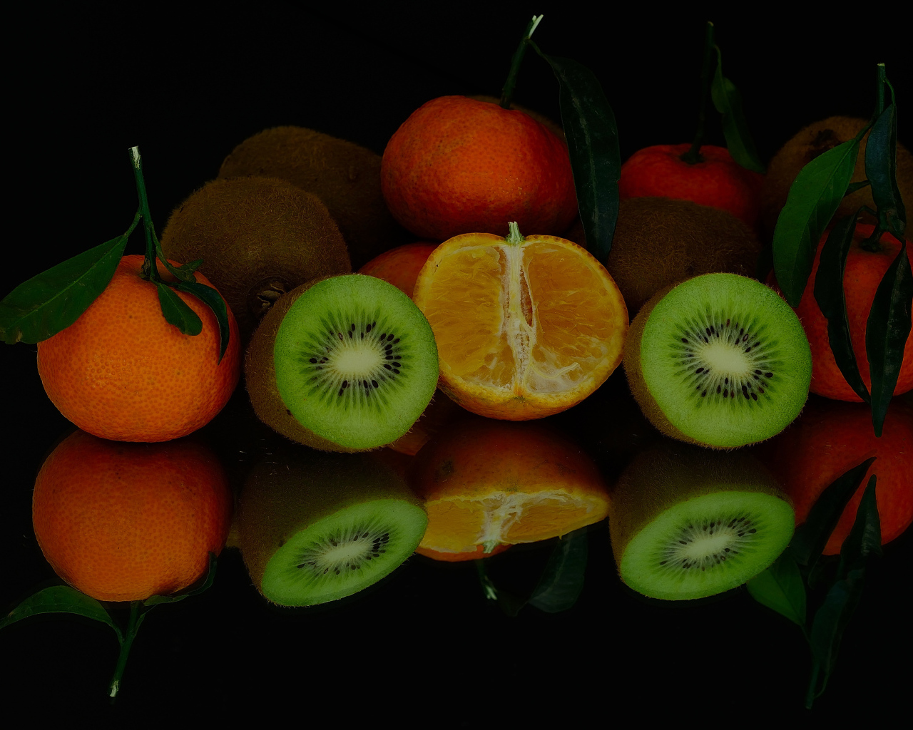 Цитрусовые фрукты на черной зеркальной поверхности