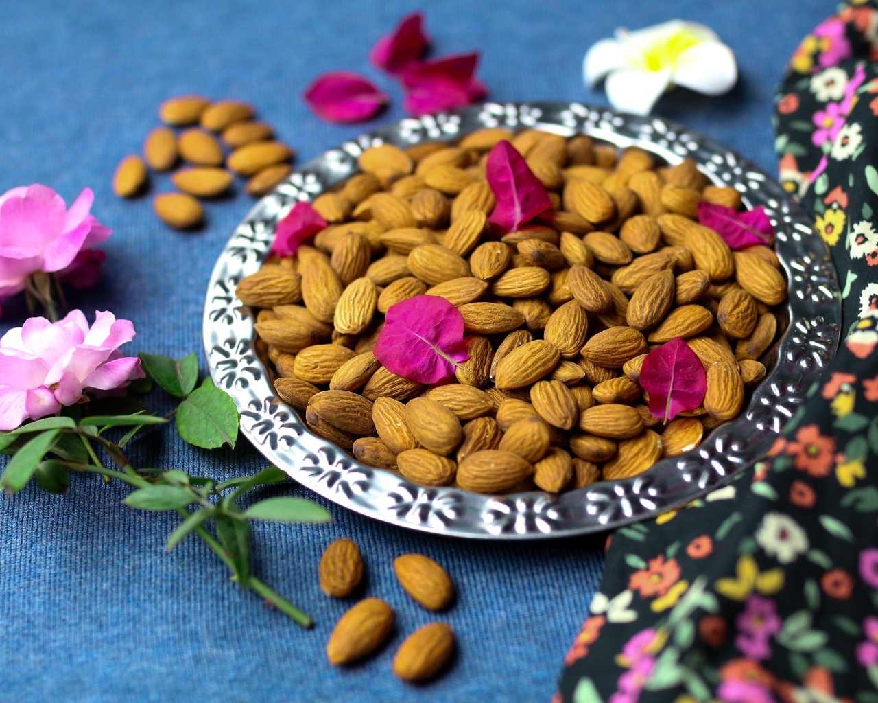 Вкусные миндальные орехи на тарелке с цветами