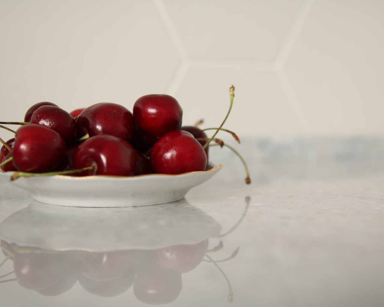 Вкусные сладкие черешни на белой тарелке