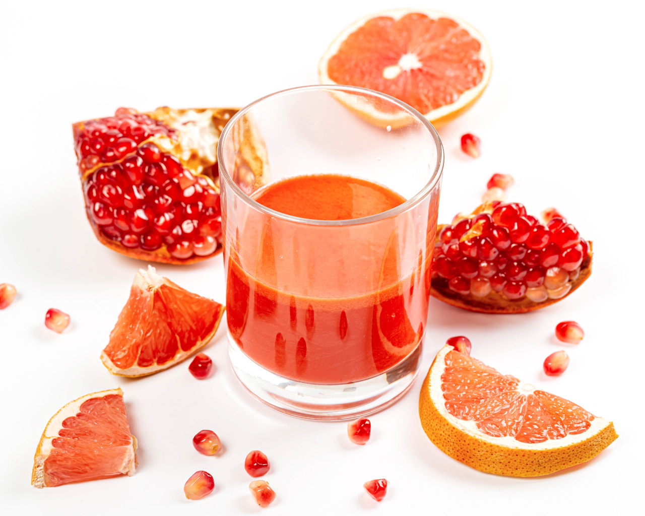 Грейпфрут и гранат на столе с соком