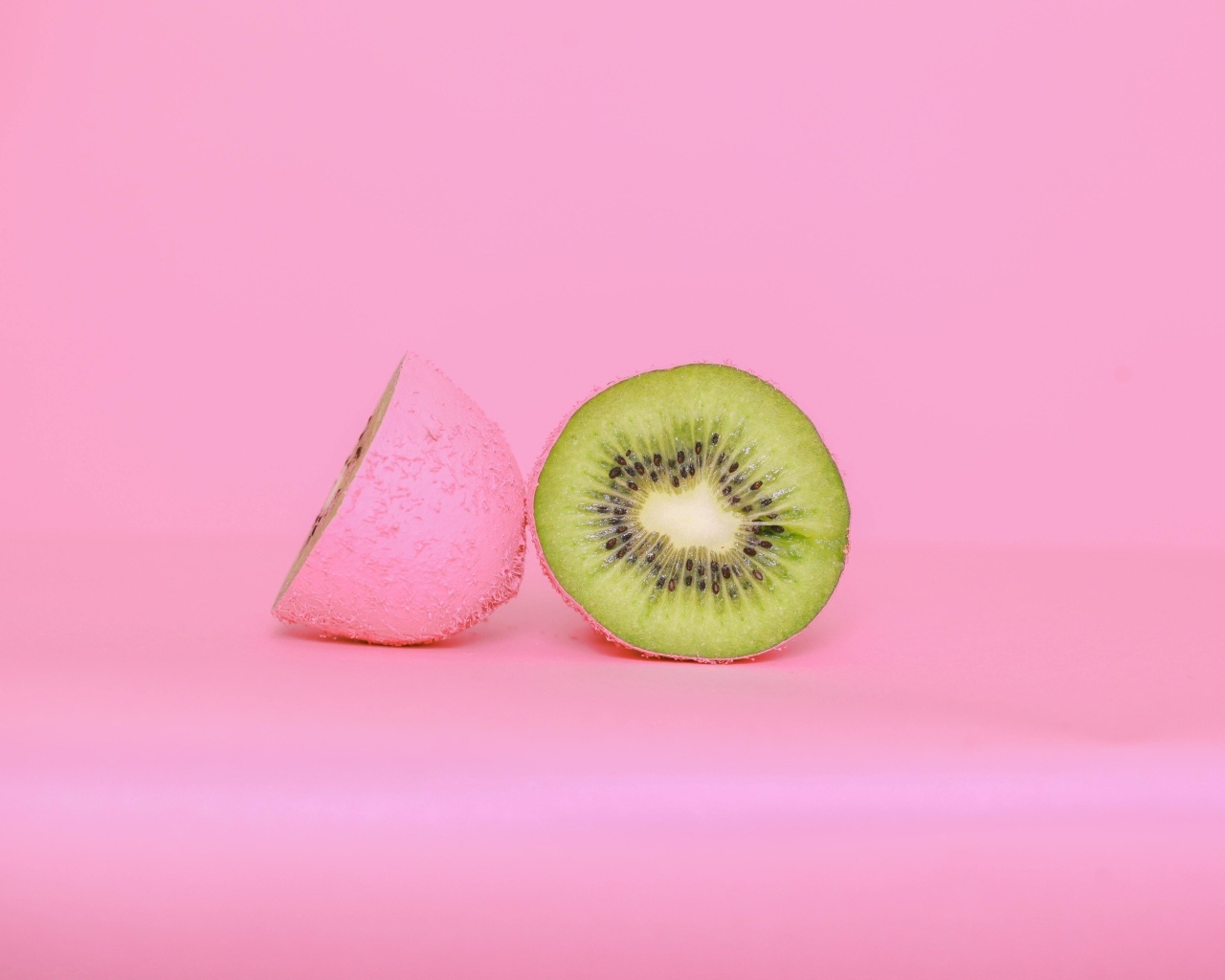 Половинки киви на розовом фоне