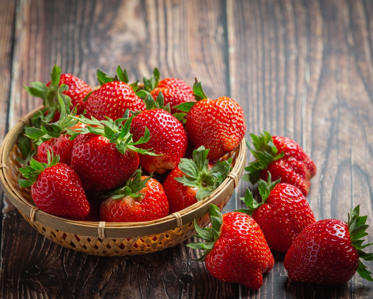 Много спелой красной клубники в деревянной посуде 