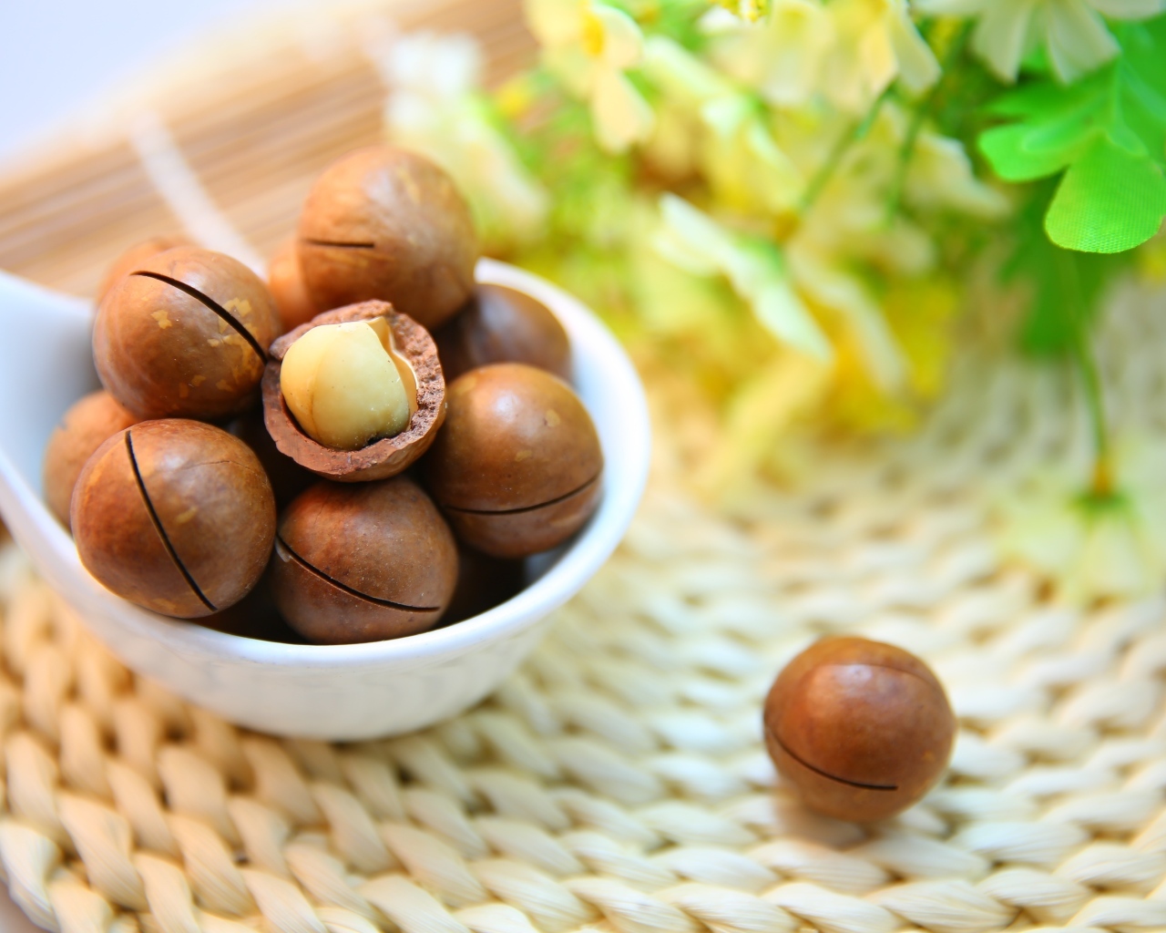 Орехи макадамия на столе с цветами