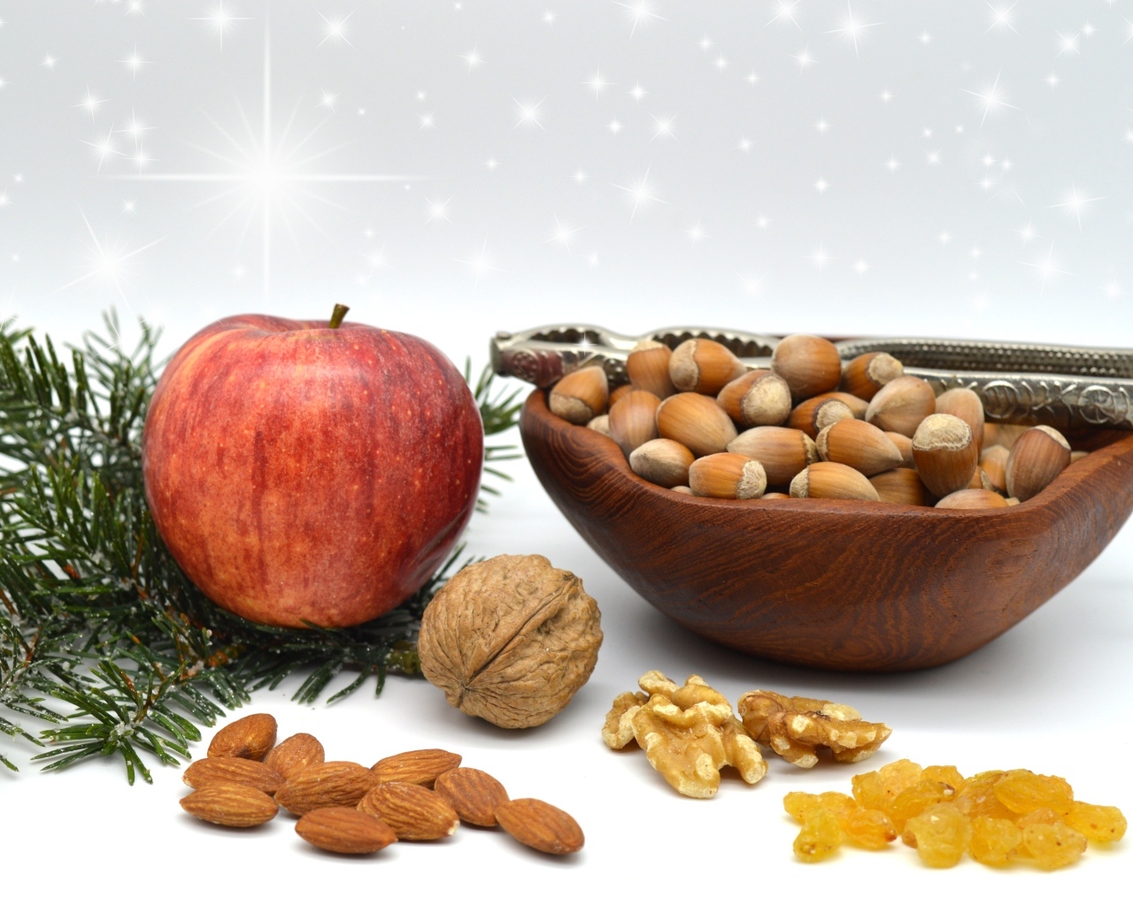 Орехи с яблоком и еловой веткой на столе