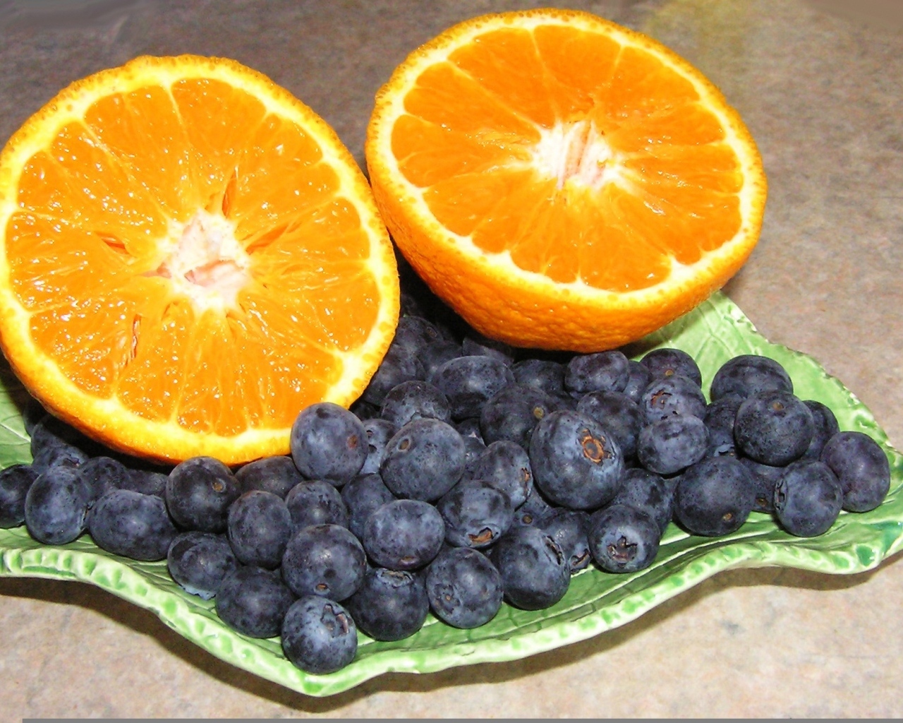 Половинки апельсина с ягодами черники на столе