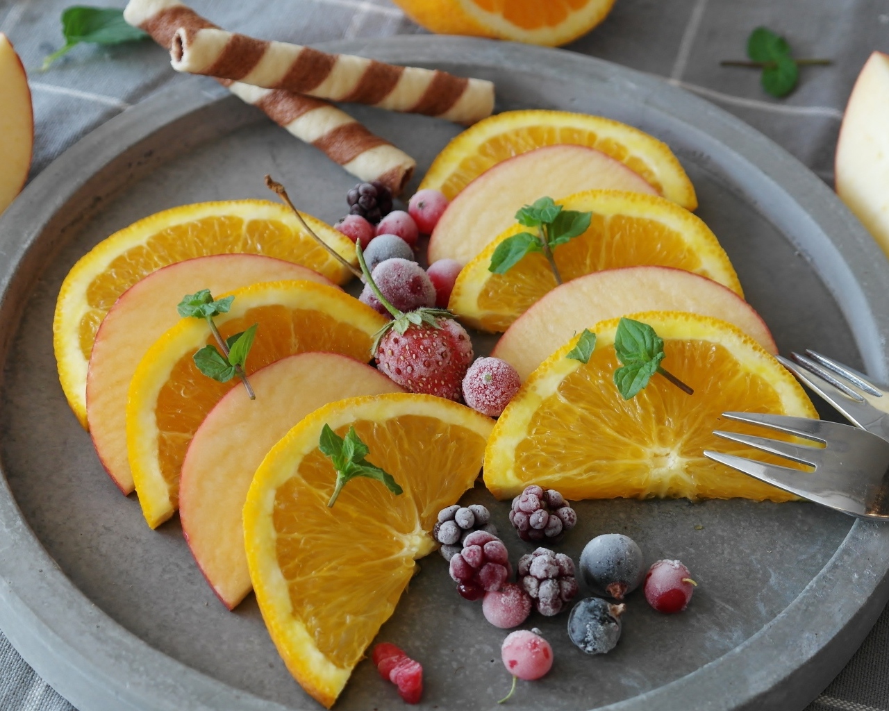 Кусочки апельсина с яблоком и замороженными ягодами