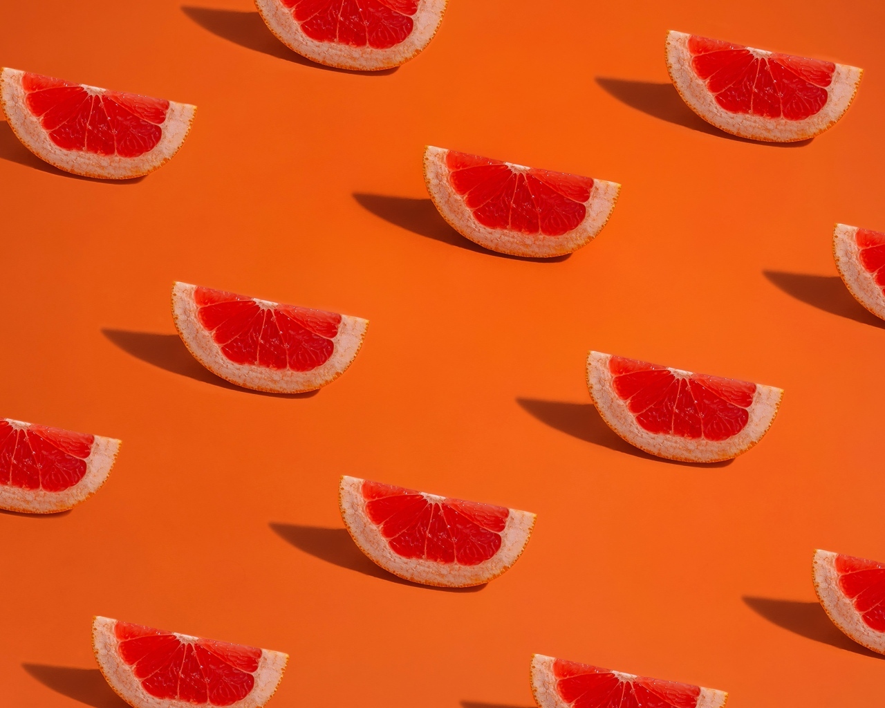 Кусочки грейпфрута на оранжевом фоне