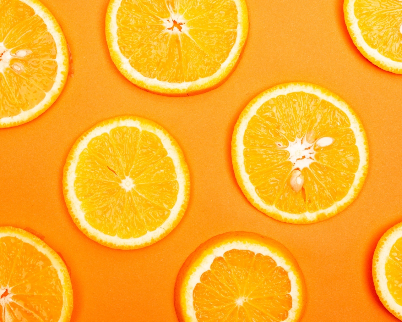 Спелый апельсин на оранжевом фоне