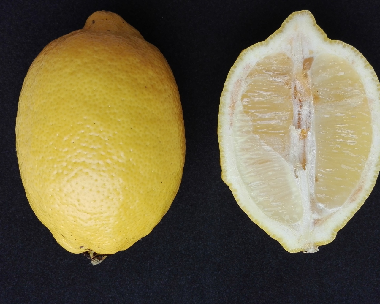 Разрезанный лимон на черном столе
