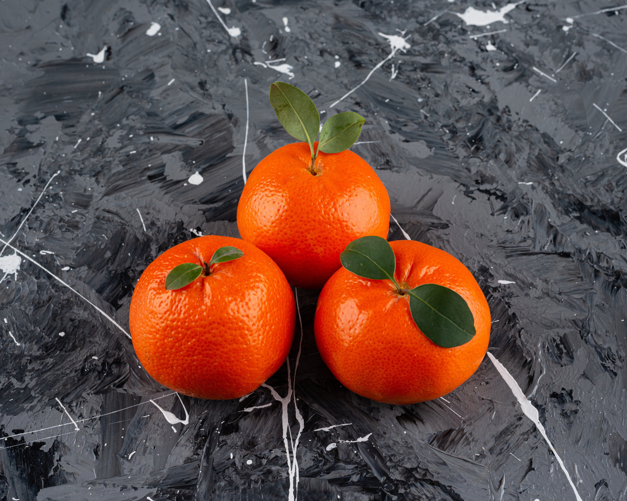 Три мандарина на сером столе