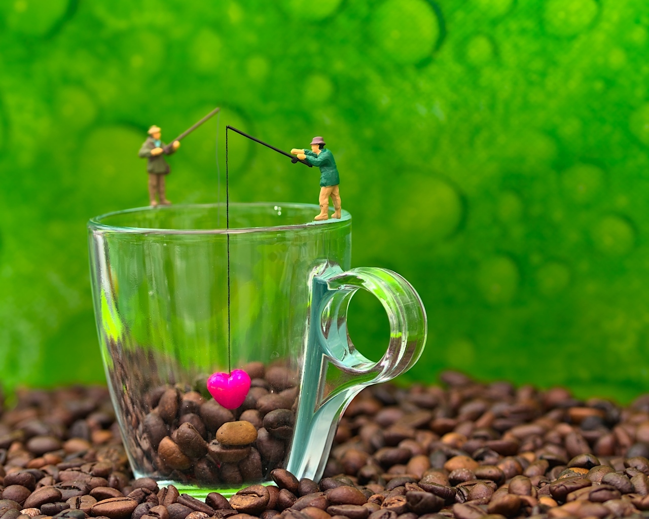 Две фигурки на стеклянной чашкой с кофейными зернами