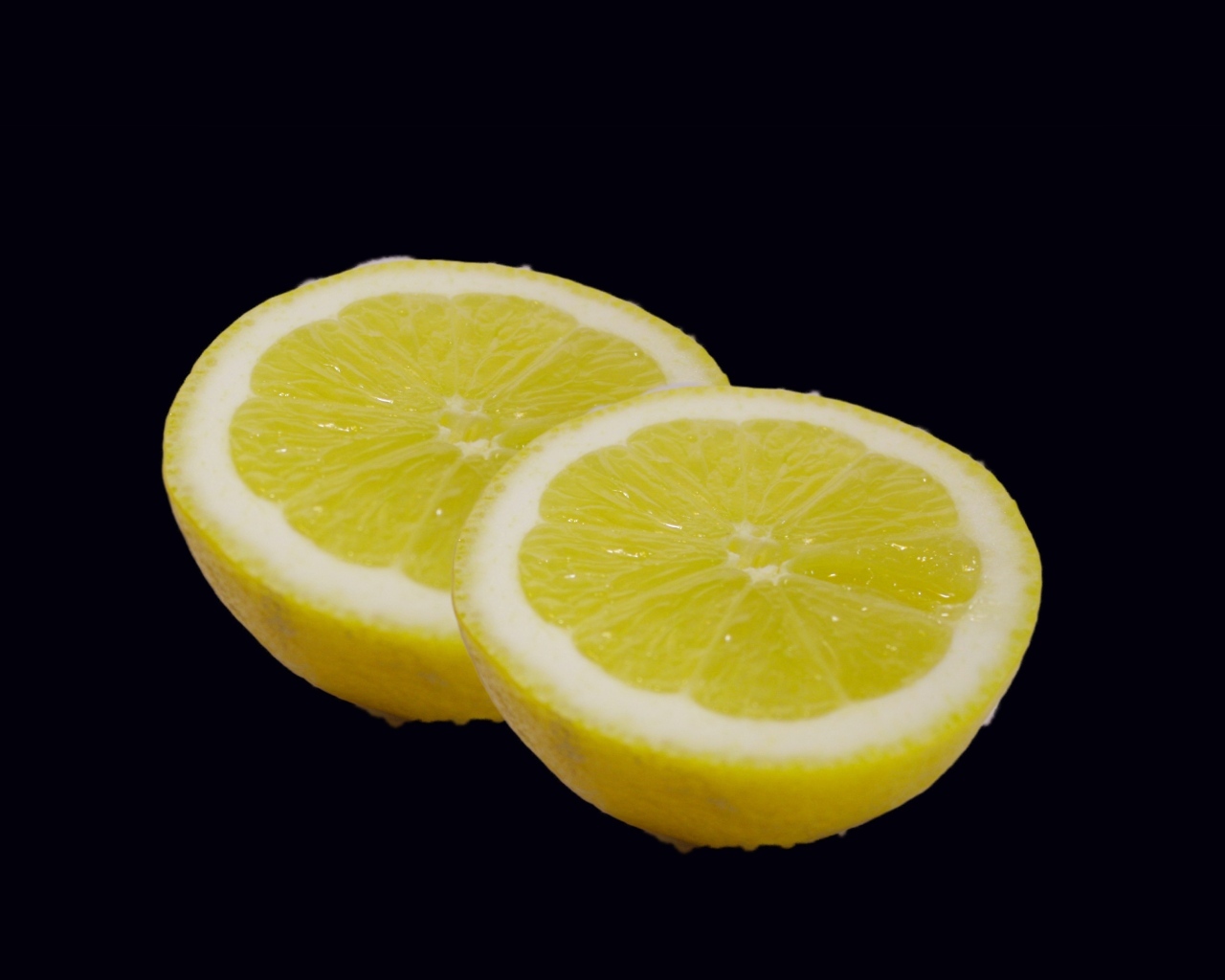 Две половинки лимона на черном фоне