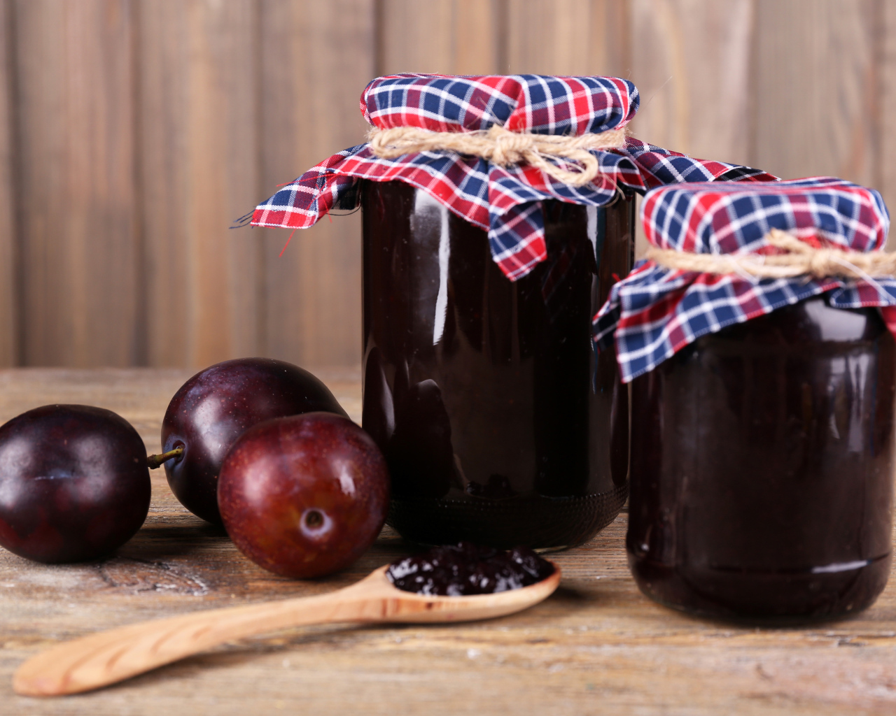 Две банки джема на столе со сливами