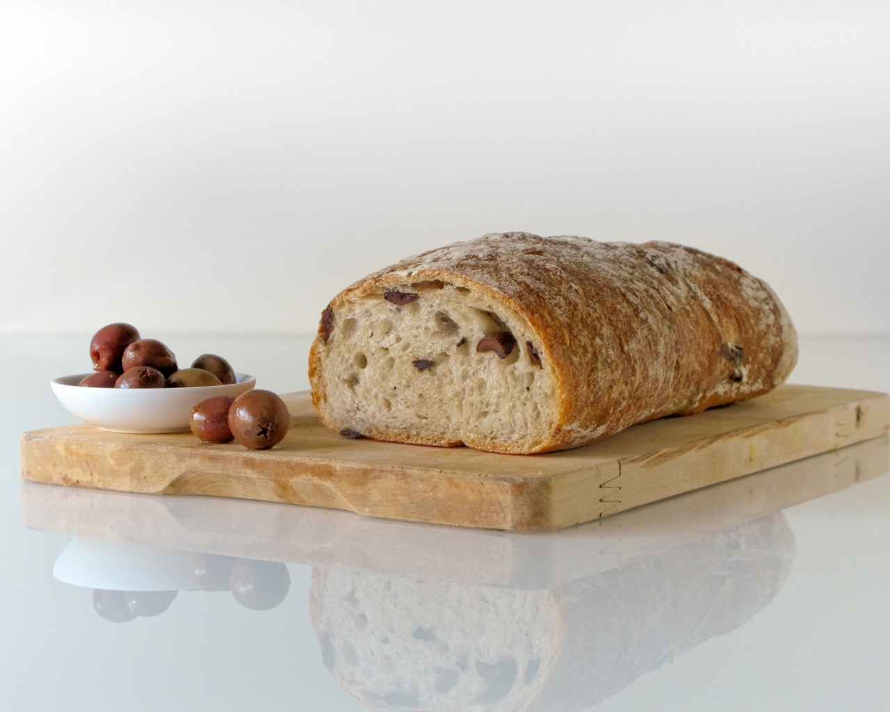 Свежий хлеб с оливками на разделочной доске